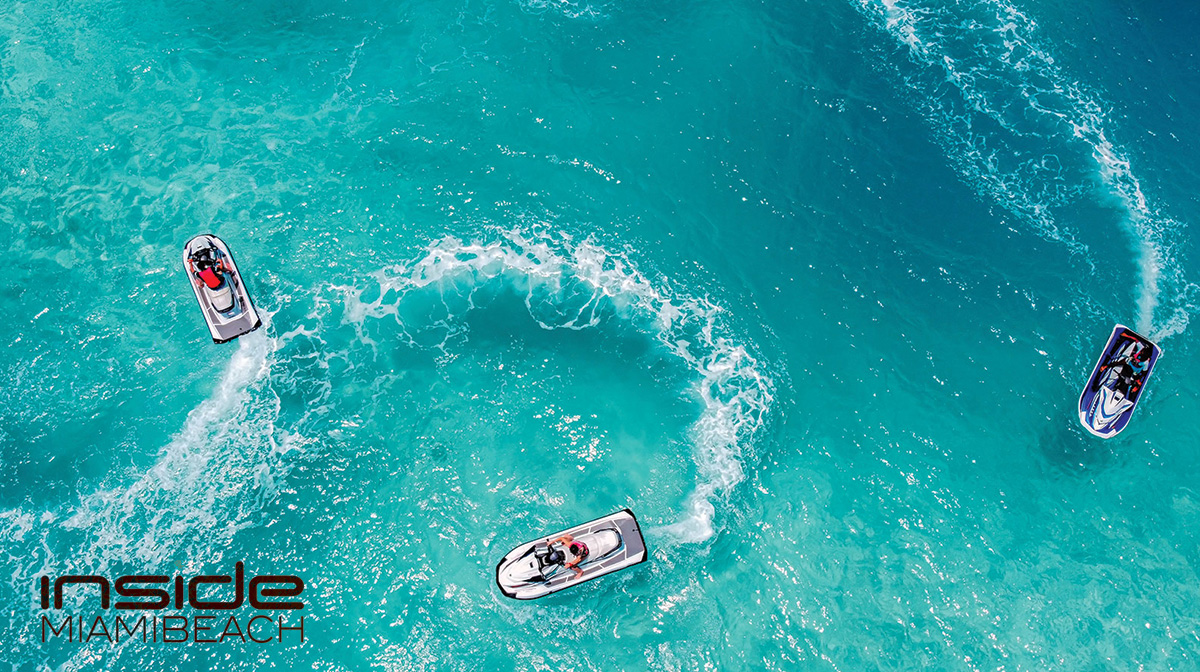 Three jet skis slice through Sunny Isles' waves, a dance of adrenaline under the bright sun.