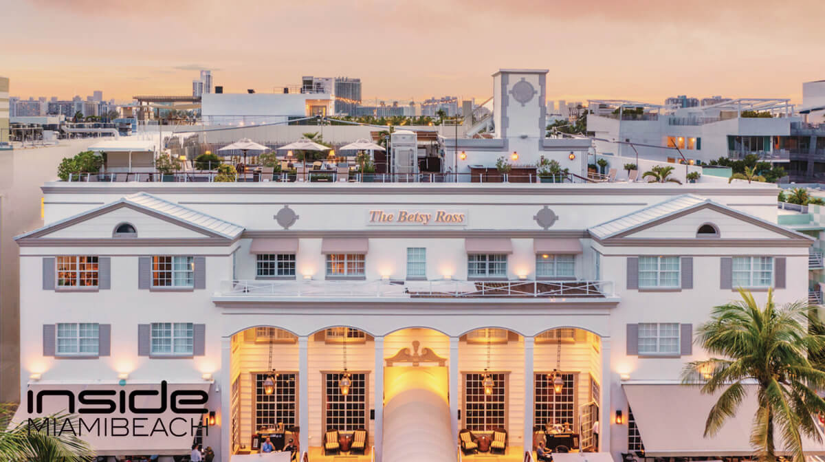 The Betsy Hotel's façade on Ocean Drive, beautifully illuminated at night, showcasing its iconic Miami charm and architecture